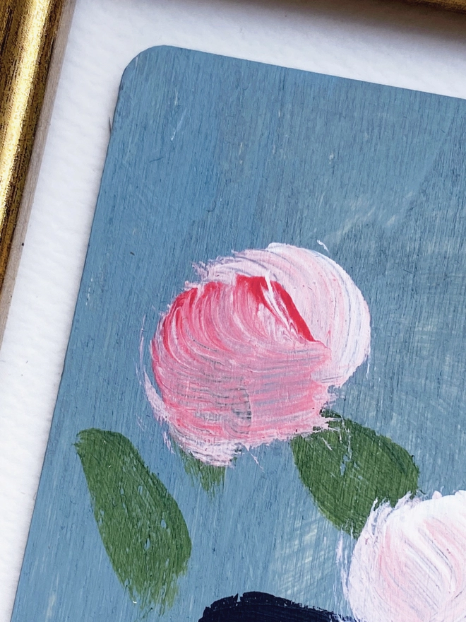 close up of picture of three painterly pink flowers on dusty blue background in a cream and gold 1960's style frame
