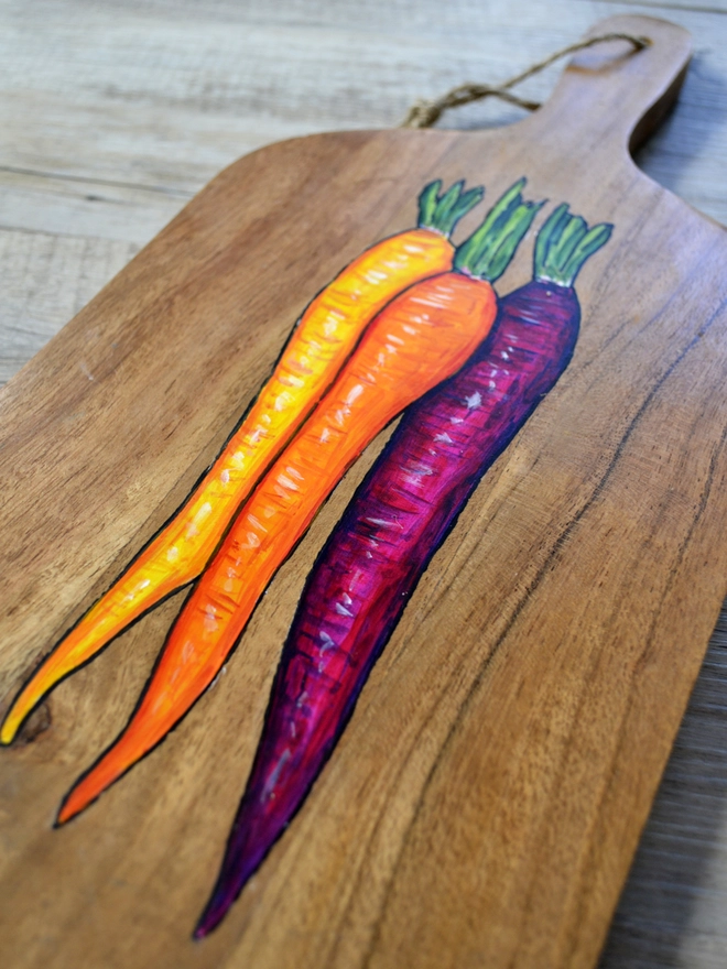 Wooden serving board with a handpainted carrots design