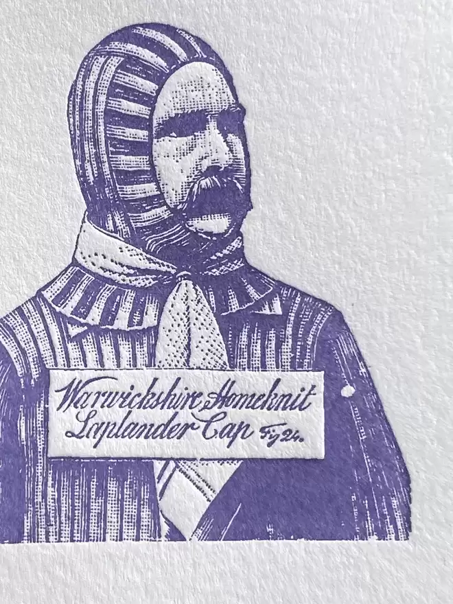 Close up of a white card with purple illustration of a man in a balaclava with text reading 'Warm Wishes'.