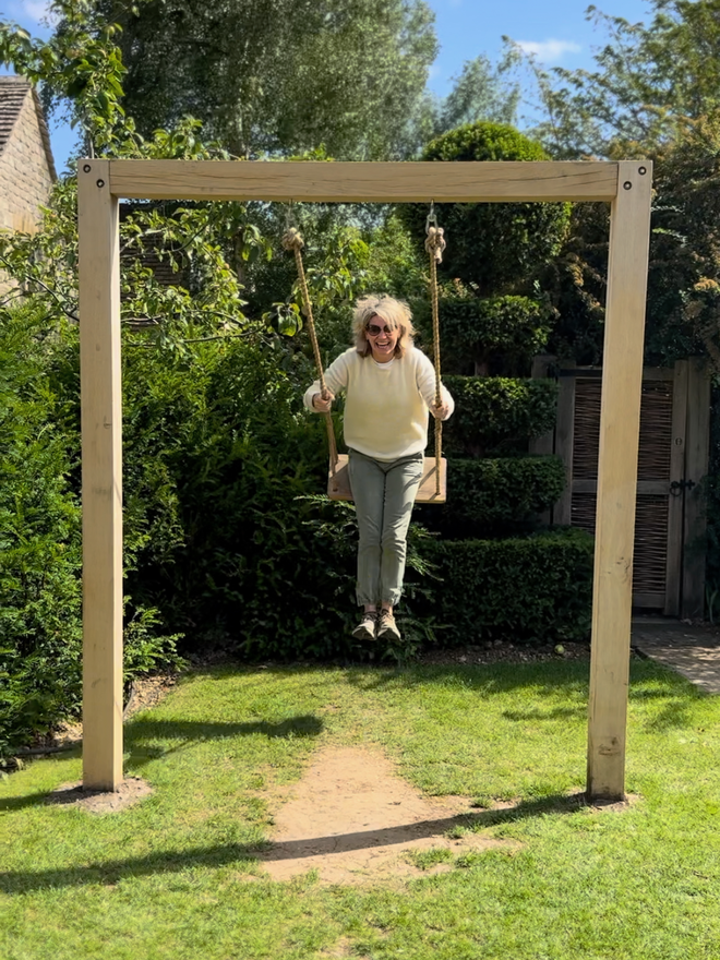 Jeanette swinging on a swing frame