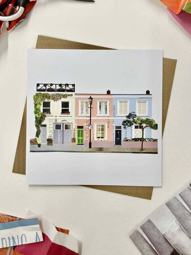 Greetings Card with a collaged illustration of Notting Hill with an envelope on a white background with collage materials.