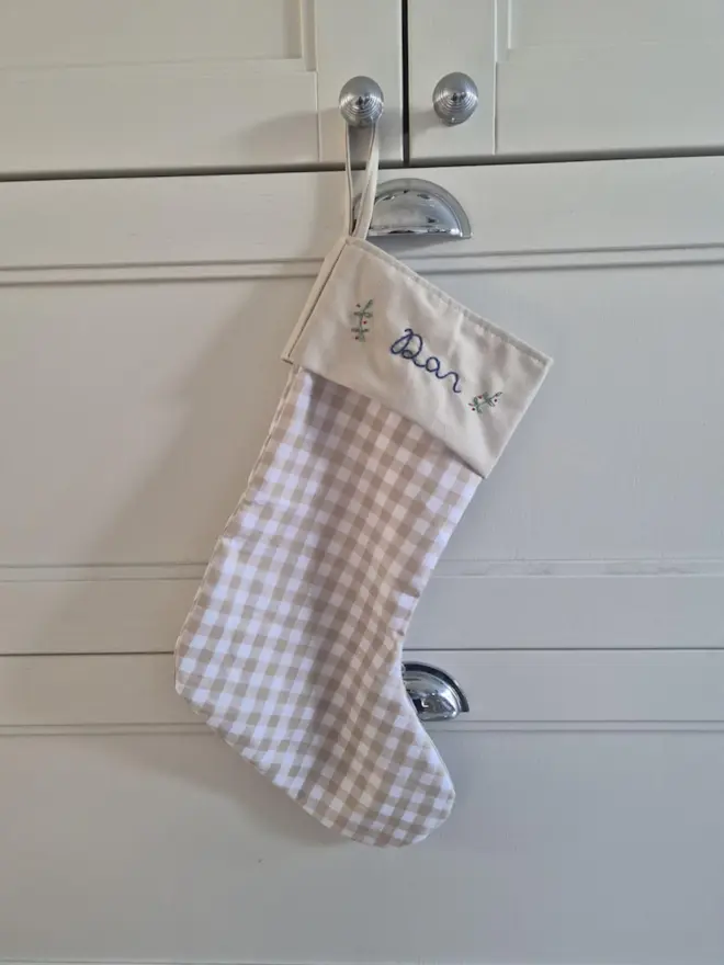 red gingham stocking with personalised embroidered name hanging