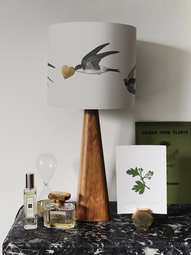 Handmade lampshade featuring graceful flying swallows swooping through a nature-inspired design, adding an elegant touch to any room.
