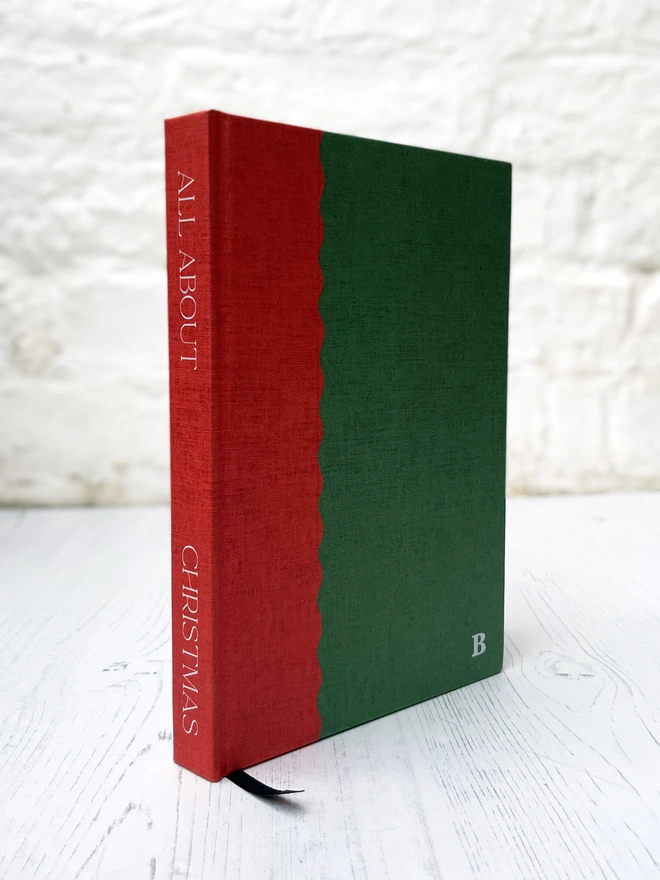 a two tone journal with a scallop edge in red and green and a personalised initial on the front and "all about christmas" written on the spine