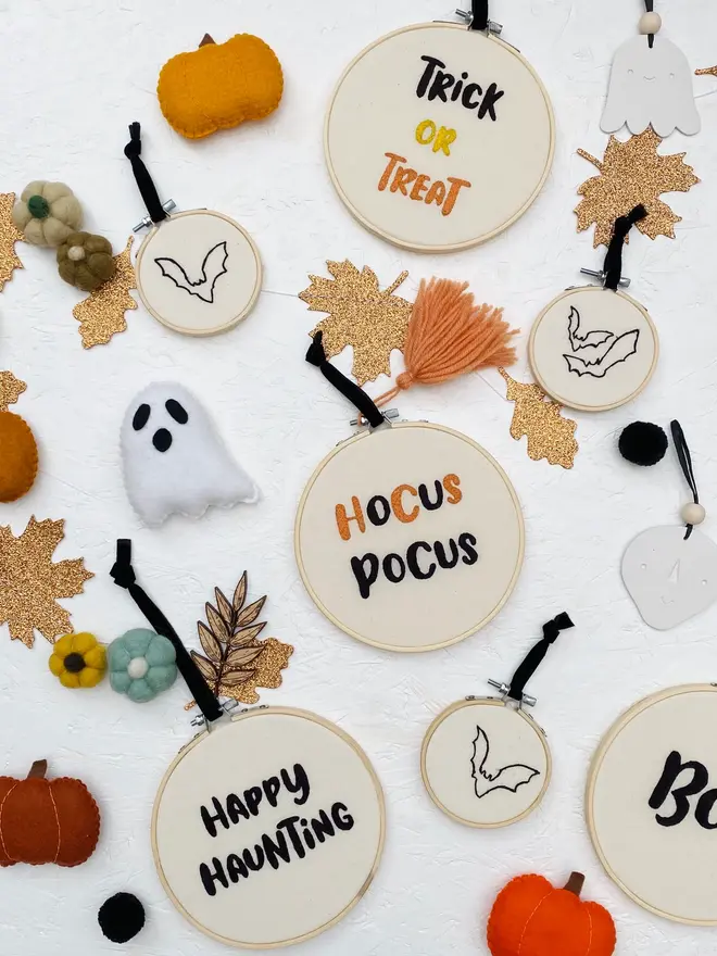 spooky phrase embroidered hoop. embroidered halloween hoops photographed with decorations.