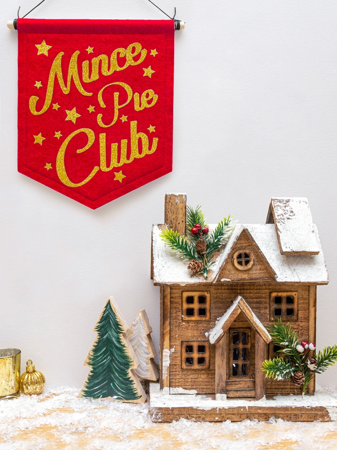 Christmas "Mince Pie Club banner" in red felt with yellow gold glitter font. The text is surrounded by glittery stars