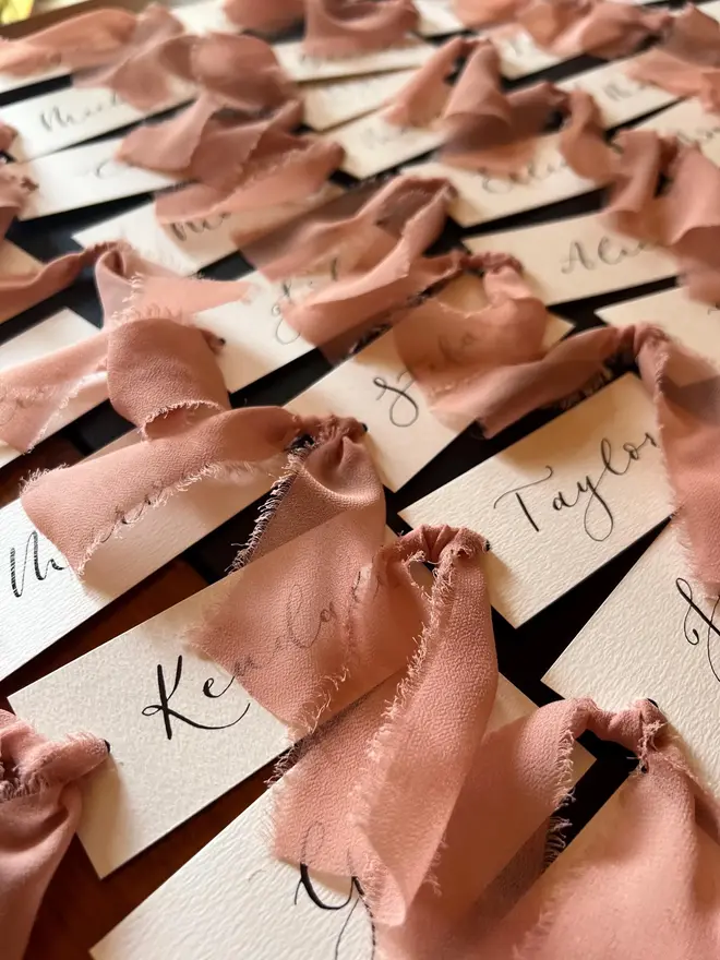 Personalised Calligraphy Wedding White Place Cards, white place cards with chiffon plum ribbon. 