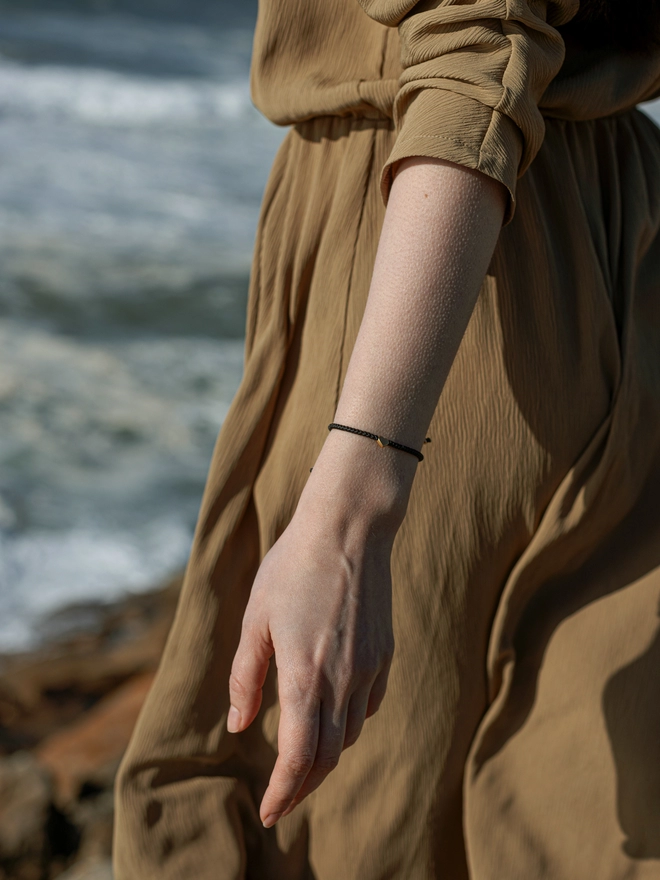 women on the beach with heart bracelet