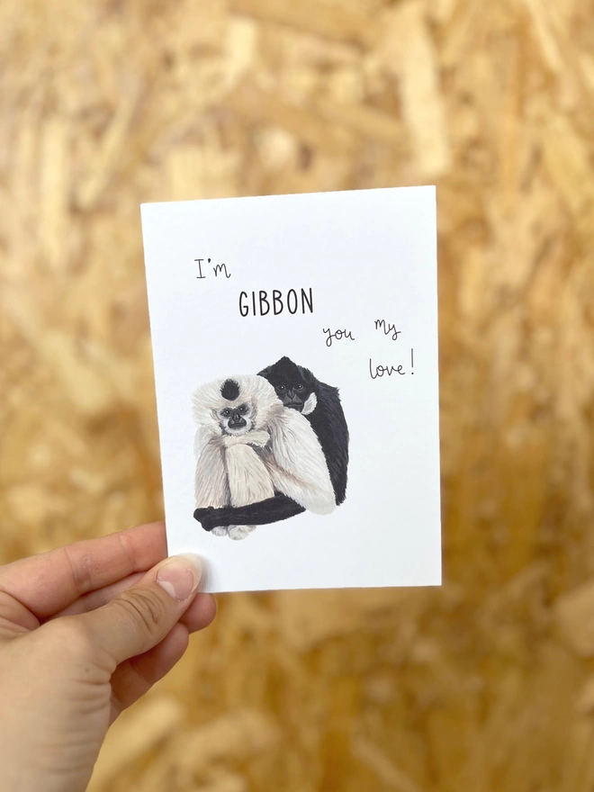 A greetings card featuring two gibbons sat side by side with the phrase “I’m gibbon you my love”