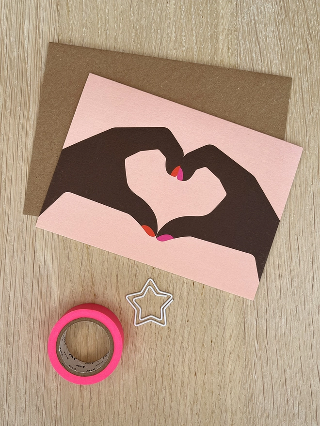 Greetings card with two hands making a heart shape