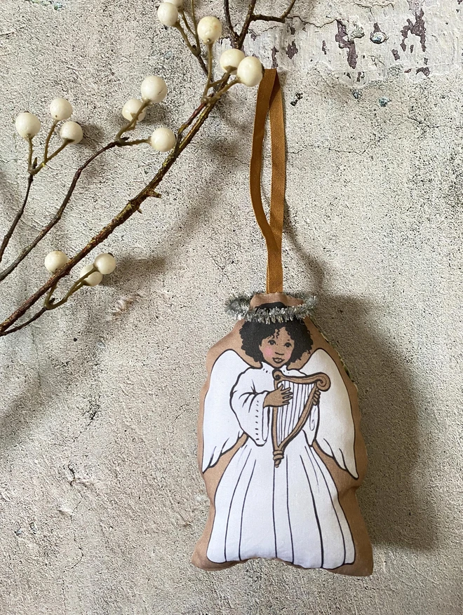 brown skinned afro caribbean christmas tree angel docoration made from printed illustrated fabric angel is holding a harp