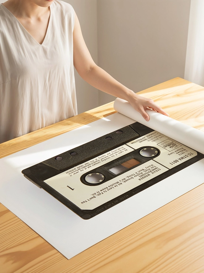 stevie wonder innervisions cassette tape print. print being unrolled on wooden table.
