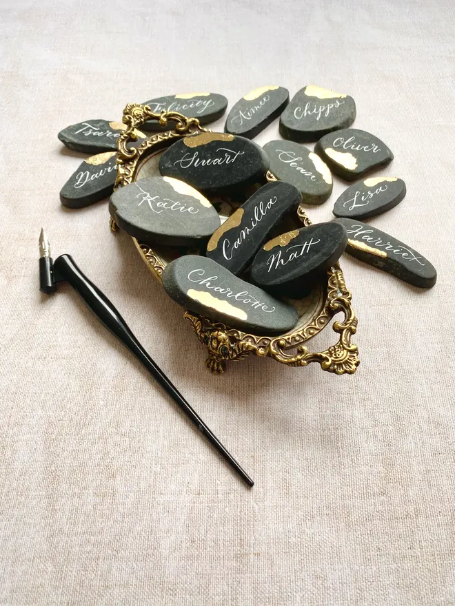 Handwritten granite stones written in white ink with gold leaf touches