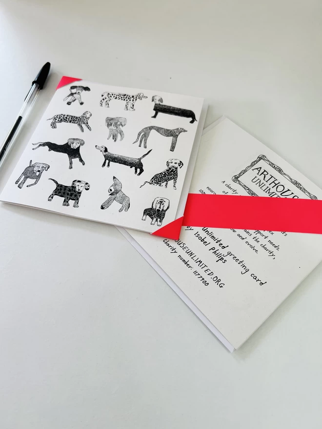 A charity card featuring hand drawn black dogs arranged in a pattern on a white background