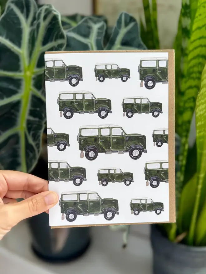 land rover defender illustrated card. card photographed with houseplants in background.