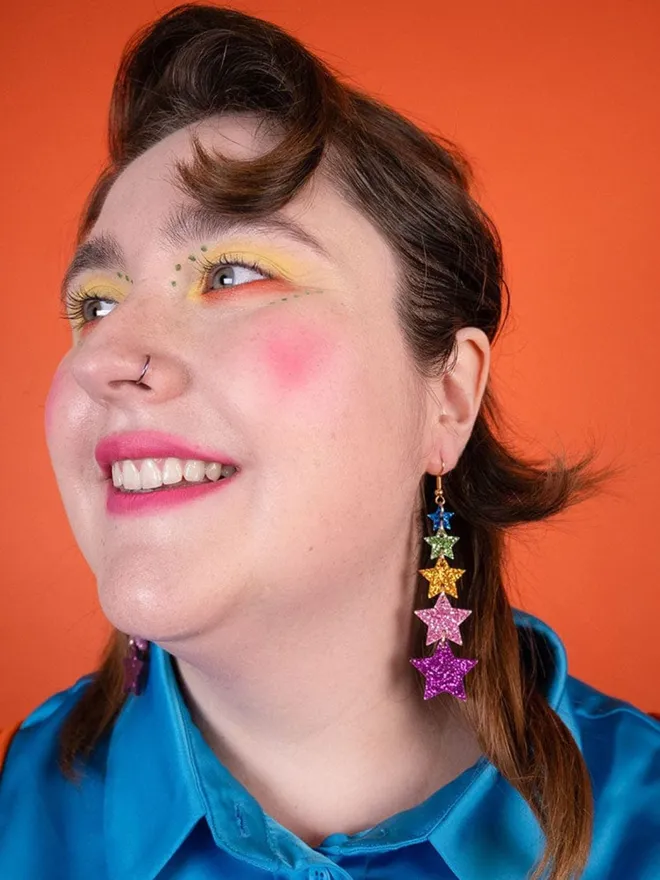 Model wearing the super star earrings in multi colour glitter