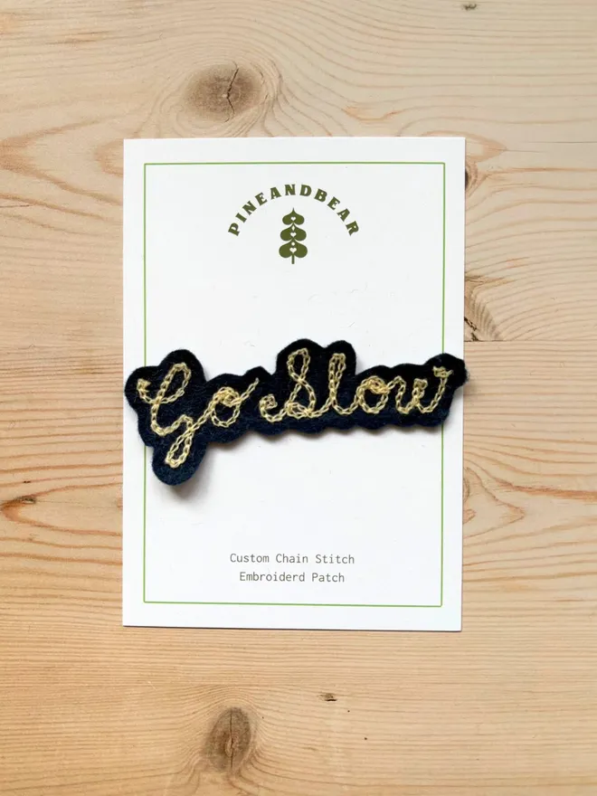 Personalised Chain Stitch name patch in navy and cream on a white presentation card