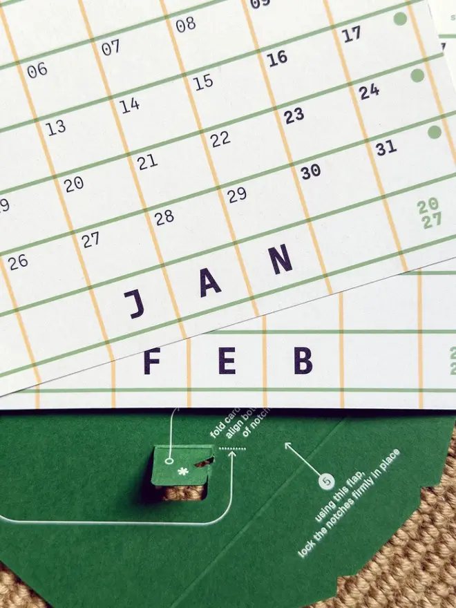 Squared: green 2027 Monthly Desk Calendar cards sitting on flat-packed stand