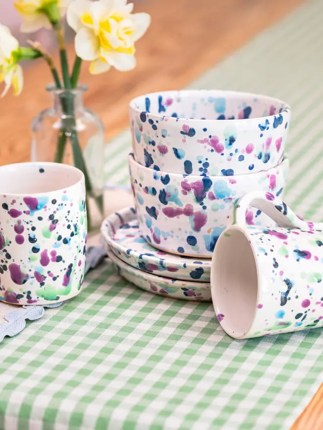Sweetpea Breakfast Dishes (Set Of 2), colourful breakfast dishes placed on a colourful table setting. They are accompanied by flowers, napkins and other cutlery. 