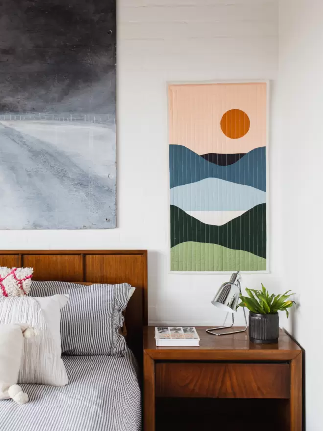 Lakeview Quilt Hanging On Wall Above Wooden Furniture In Bedroom