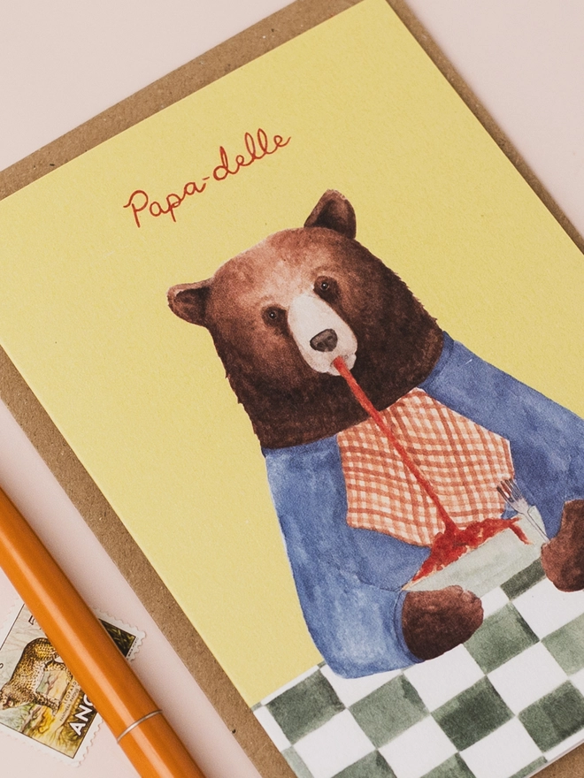 Close up of a bear father's day card with brown bear eating pappardelle