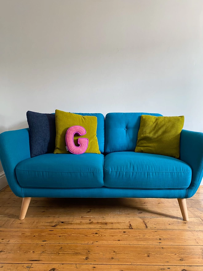 Crochet cushion shaped like the letter G in Pink and Magenta