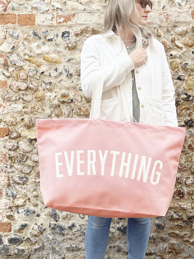 Model holding the Everything oversized canvas tote bag in Pink