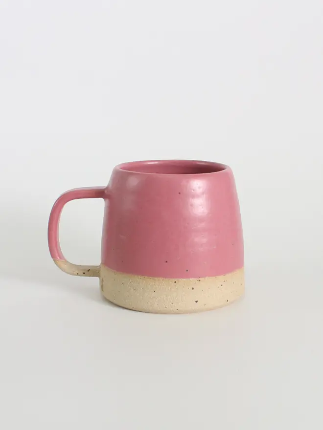 Side view of our handmade ceramic fuchsia mug against a white background.