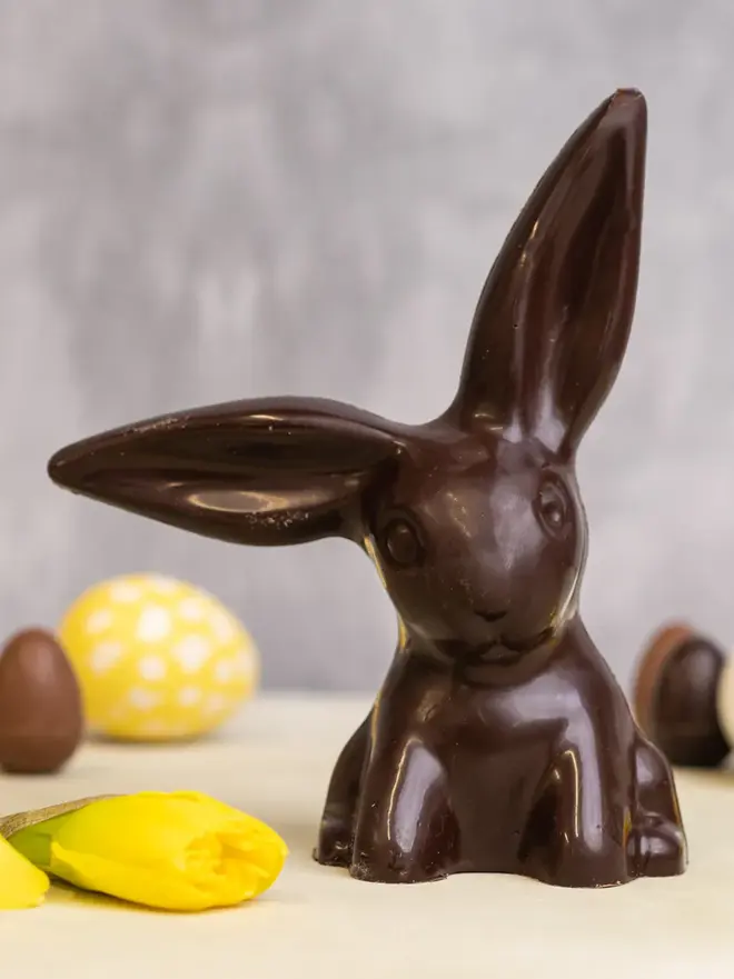 Dark chocolate easter bunny on a table with easter eggs