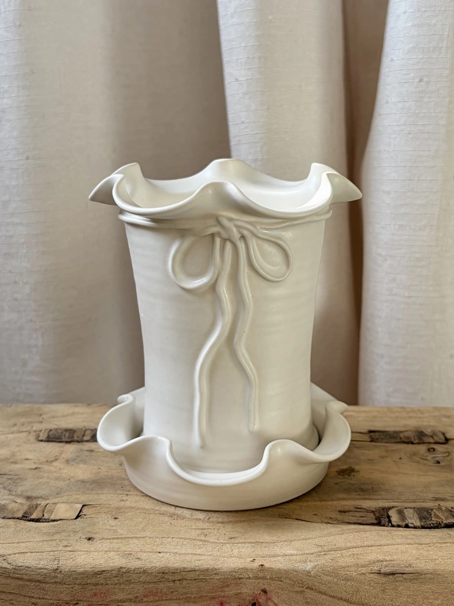 Frilly ceramic plant pot and saucer with bow in white satin glaze