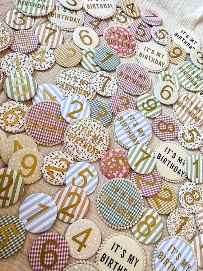 Lots of fabric birthday badges in different patterns and sizes 
