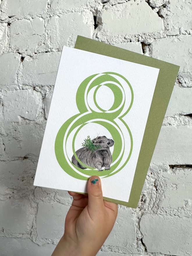 white card with a big green number 8 and a cute little pika illustration with a green envelope