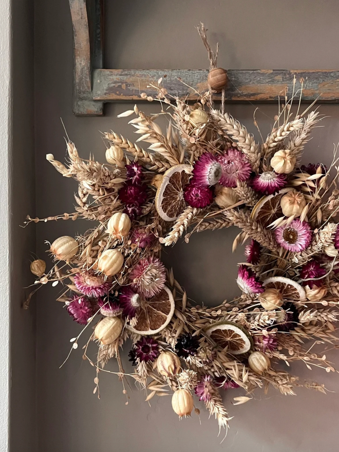 Pink Floral Dried Wreath. A pink floral wreath, hung up on a wall.