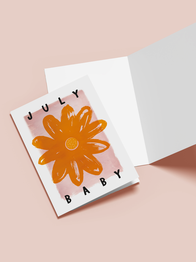 july baby illustrated card. a pink card with an orange flower in the centre.