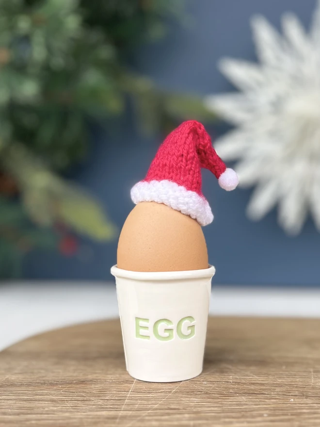 EGG is painted in green on the side of this handmade ceramic egg cup