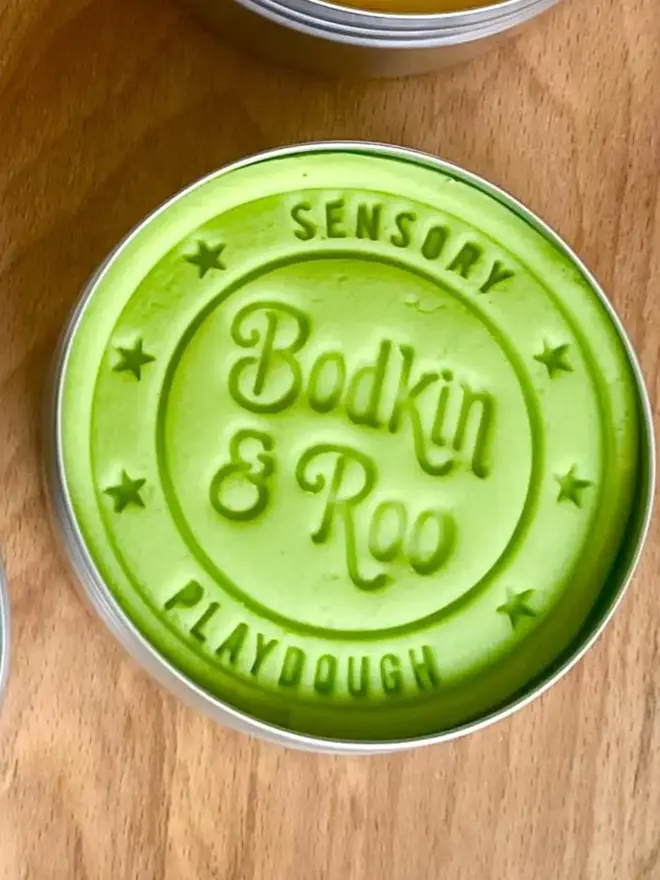 fairy sensory play dough sensory set. a tub of green play dough.