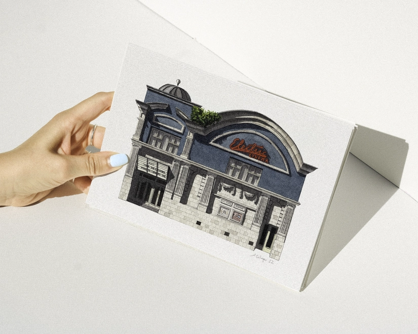 A hand with blue nail polish holding a print featuring an illustration of the Electric Cinema storefront with its blue facade and red neon sign against a white background.
