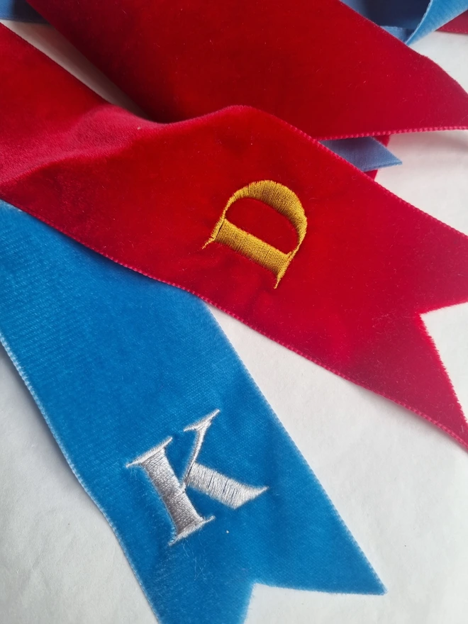 red and blue ribbons embroidered with K and D