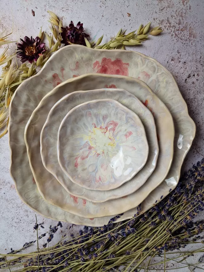 Tableware, serveware, Nesting set of four handcrafted ceramic bowls in an Dream Catcher and Rose glaze with pearlescent white and cream and pink, breakfast bowl, serving bowl, gift, potter, tableware, dinnerware, photographed on a pink background with flowers.