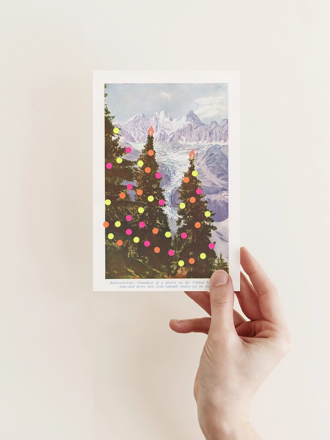 A vintage Christmas card with modern neon decorations and mountains in the distance.