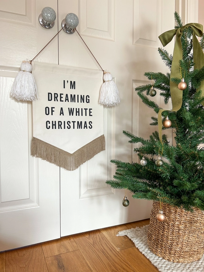 I'm dreaming of a white christmas fabric banner with white tassels and a christmas tree