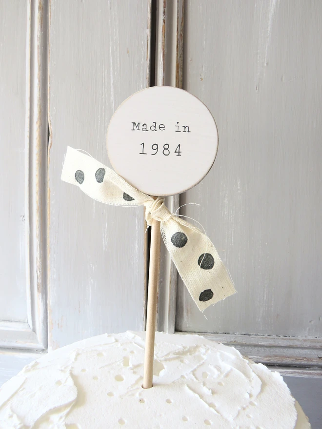 wooden circle shaped cake topper with hand painted message and custom ribbon