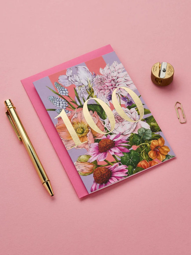 floral age milestone card. a pink floral 100th birthday card photographed against a pink background.