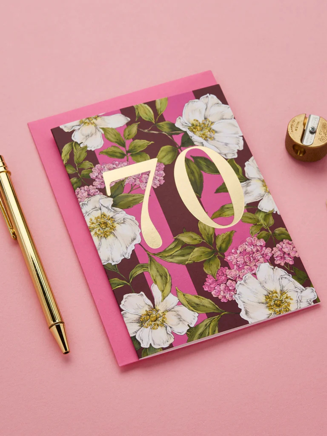floral age milestone card. a pink floral 70th birthday card photographed against a pink background.