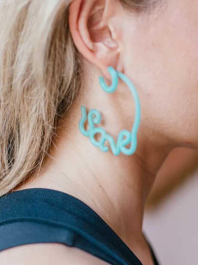 100% Recycled Ocean Plastic - 'Save' 'Earth' Hoop Earrings seen on a woman.