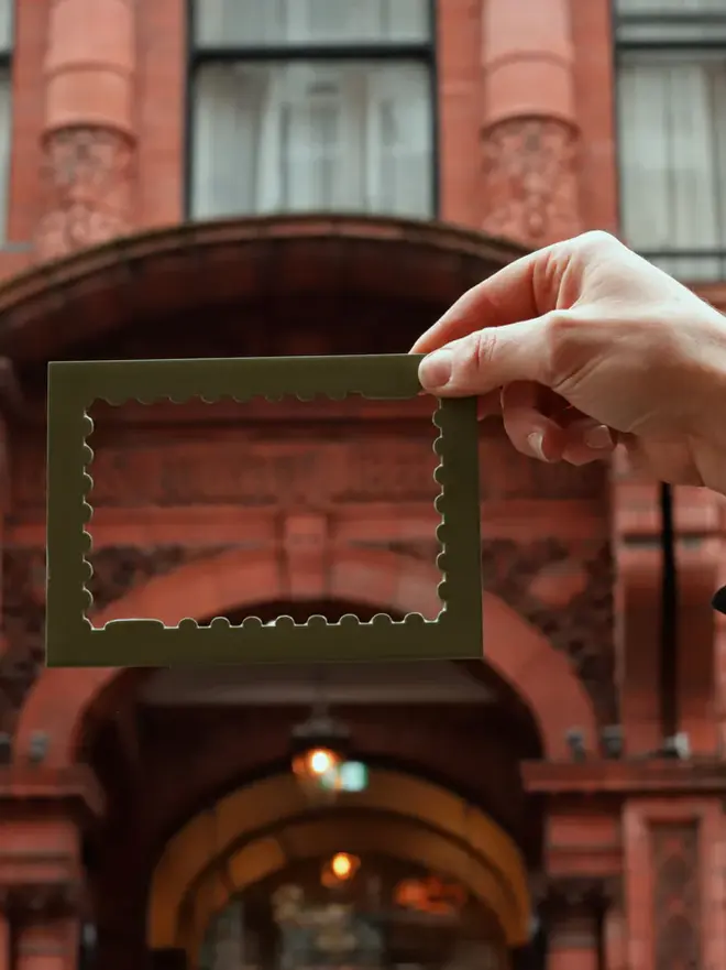 person holding empty olive stamp shaped frame mount