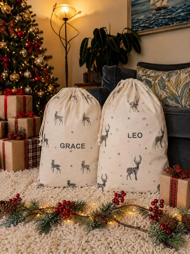 personalised drawstring christmas sack. two drawstring bags with printed christmas motifs and personalised names.