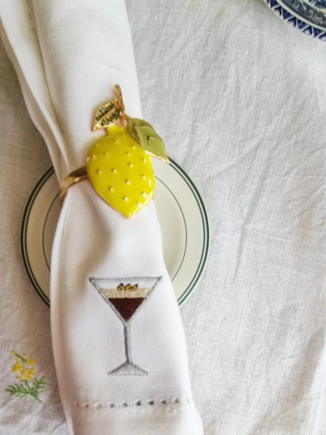 A white napkin with an espresso martini embroidered motif
