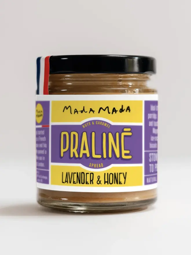 jar of lavender and honey praline nut butter spread, with yellow and purple label and black lid