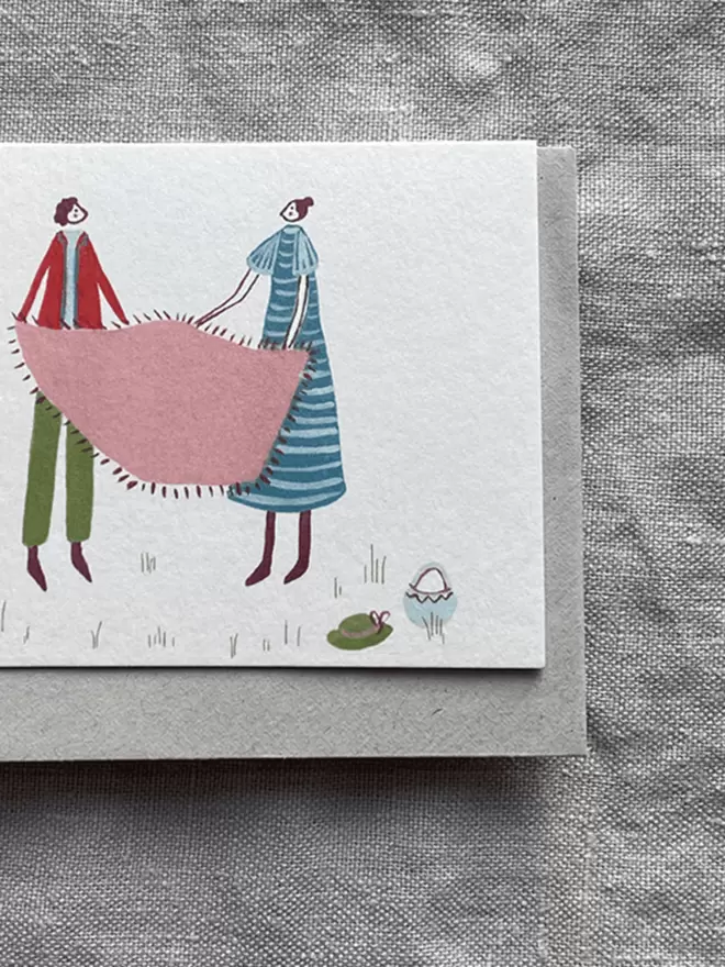 greetings card with 2 people having a picnic on it.